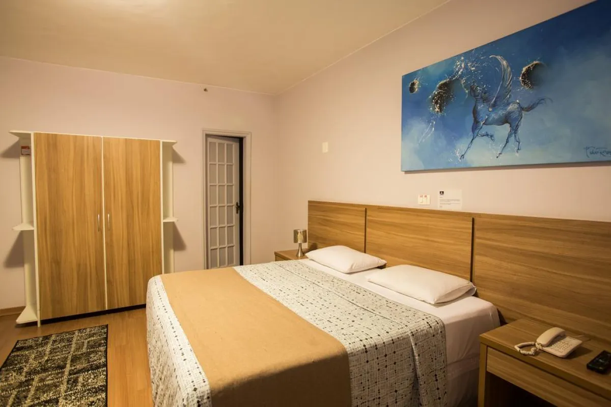 Quarto Luxo do Gallant Hotel com cama de casal e armário